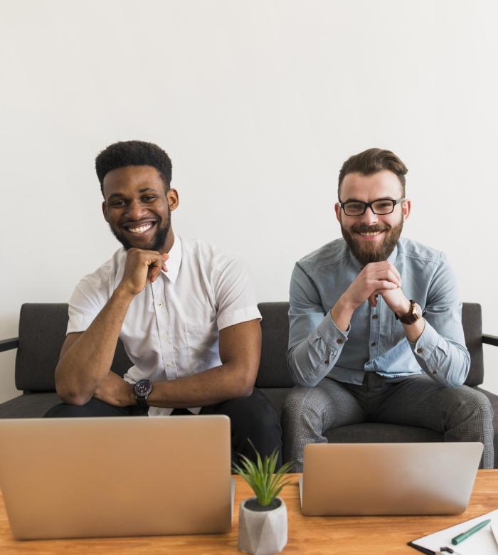cheerful-men-near-laptops